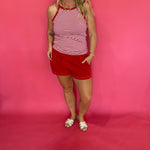 Close-up of the lattice cutout trim along the hem of the red Aria tie front shorts