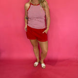 Close-up of the lattice cutout trim along the hem of the red Aria tie front shorts
