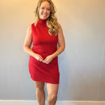 Close-up of the ribbed knit texture and crew neckline on the red sleeveless sweater dress