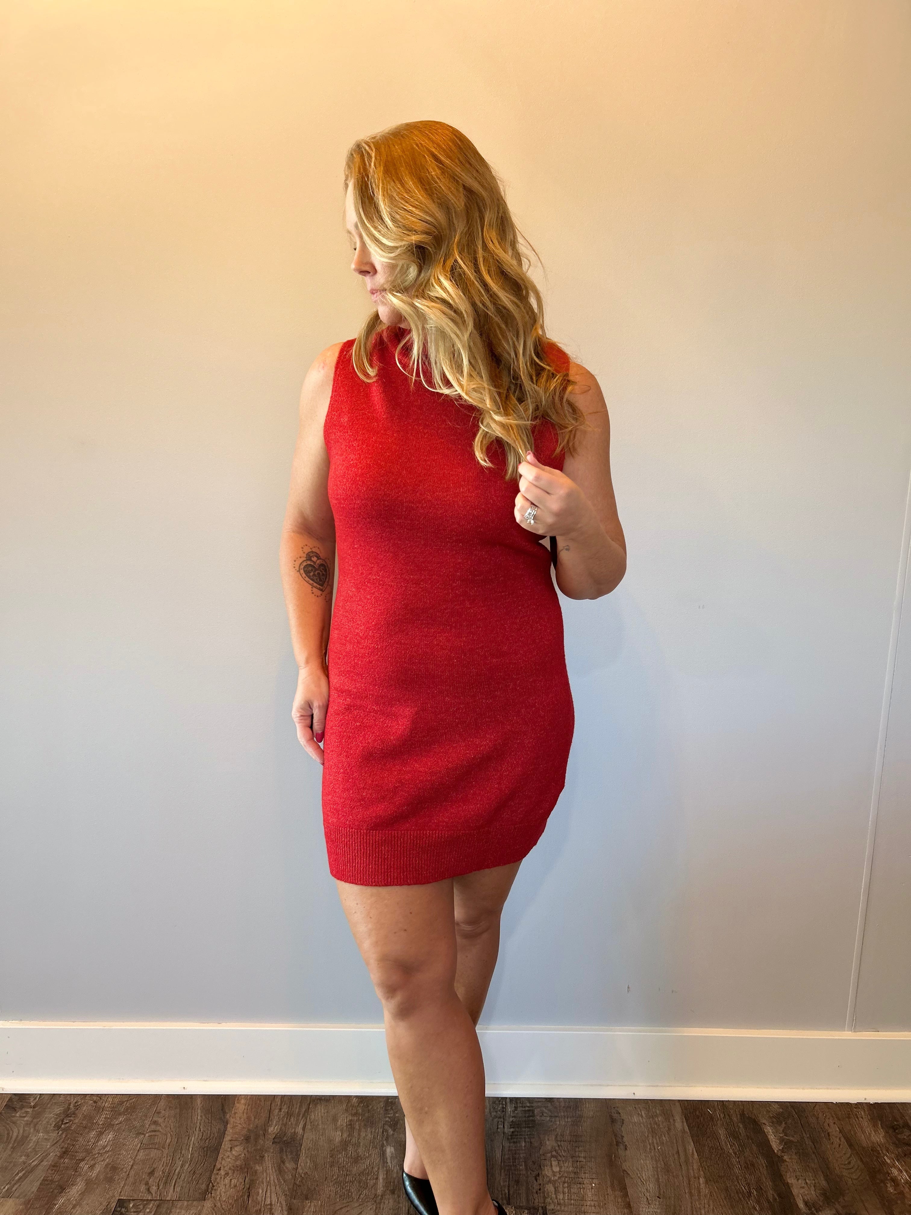 Side view showing the body-skimming fit and midi hemline of the red knit sweater dress