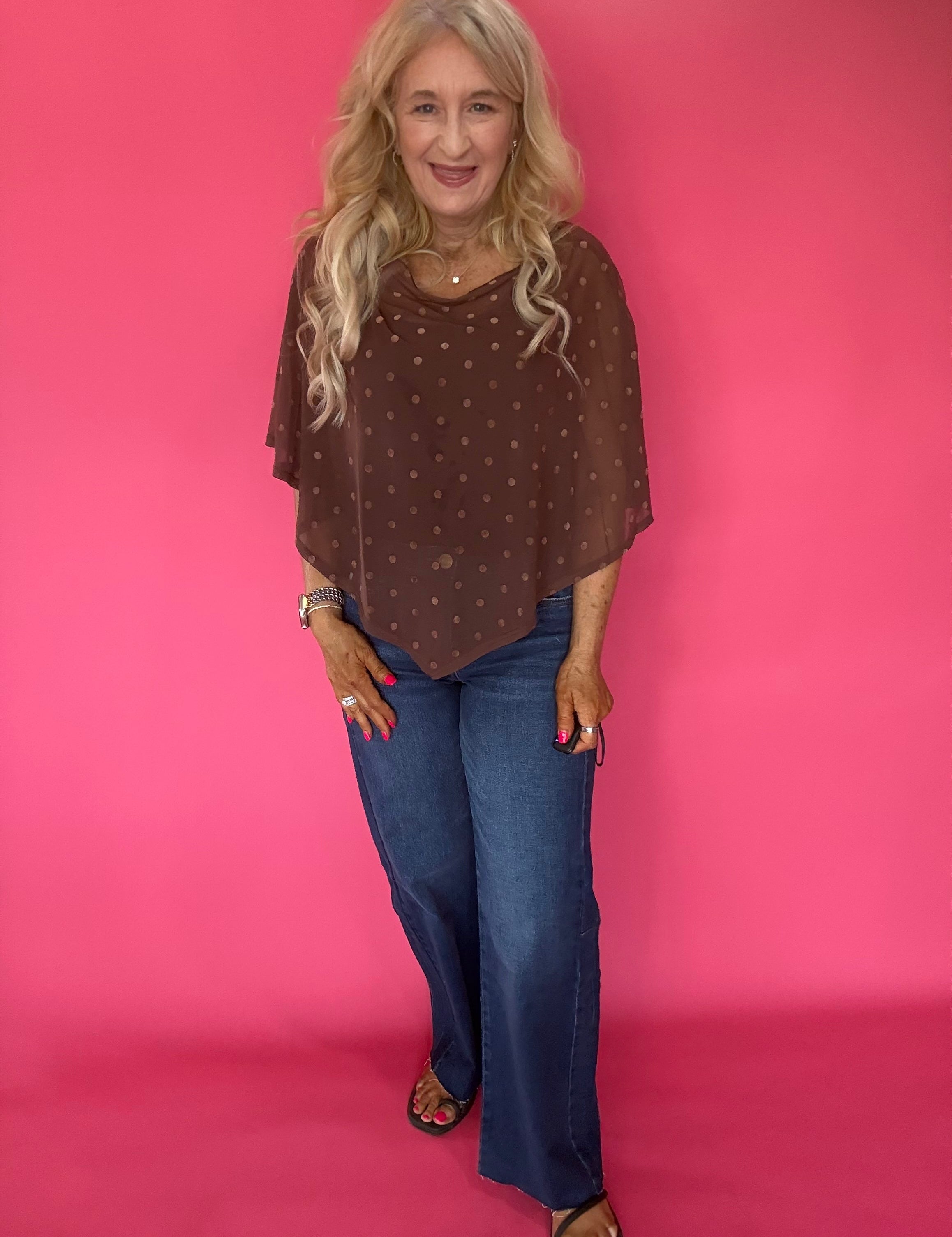 Back view of the brown dot mesh poncho showing the draped handkerchief hem falling past the hip