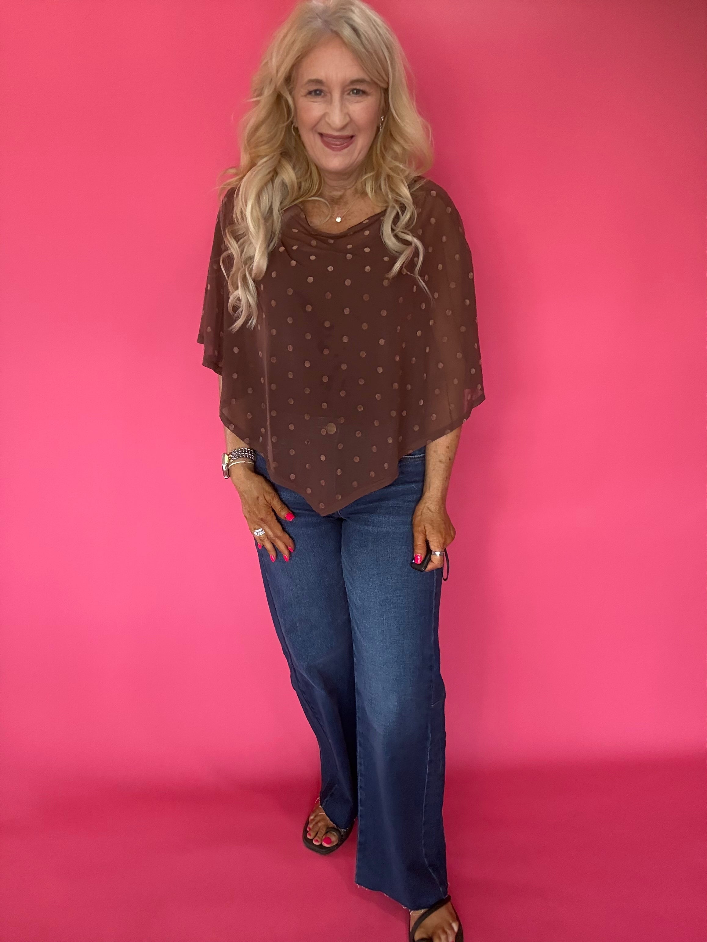 Back view of the brown dot mesh poncho showing the draped handkerchief hem falling past the hip