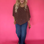 Side view showing the one-shoulder drape and asymmetric handkerchief hem of the brown mesh poncho