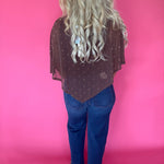 Detail of the brown polka dot mesh layered over a fitted top and high-waisted trousers