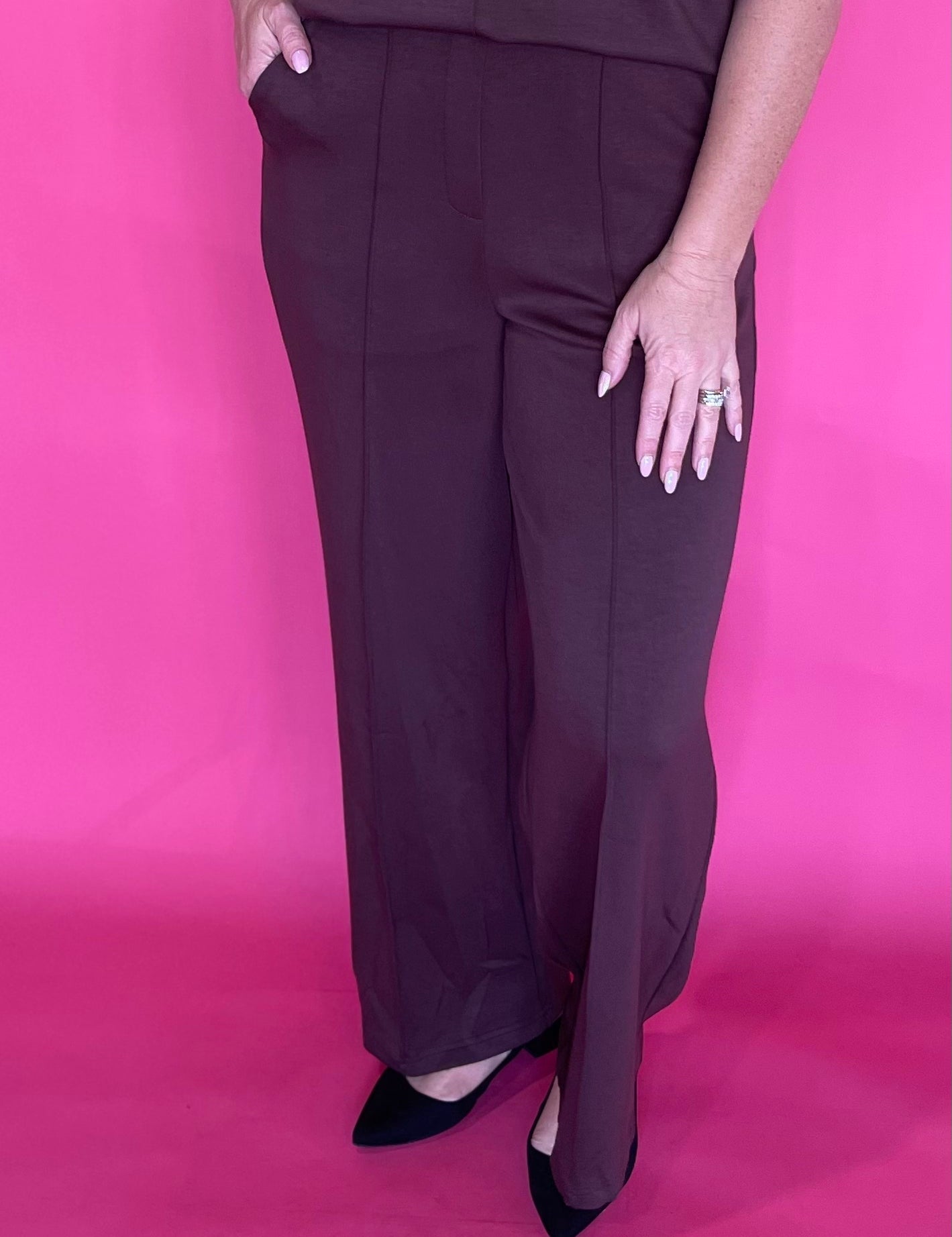 Woman wearing soft brown everyday trousers with a tucked blouse and low heels for work