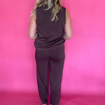 Full length view of the brown everyday trousers worn with a tucked blouse and low heels