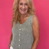 Woman wearing a sage green button front sweater vest with a V-neckline and relaxed fit