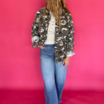 Close-up of the green camouflage print fabric and chest pocket flap on the jacket