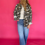 Close-up of the green camouflage print fabric and chest pocket flap on the jacket