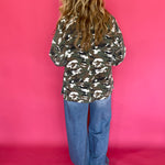 Detail of the button front and cuff on the loose fitting green camo print jacket