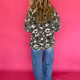 Detail of the button front and cuff on the loose fitting green camo print jacket