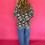 Detail of the button front and cuff on the loose fitting green camo print jacket