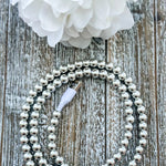 Gold pearl beaded 2 in 1 phone charging cable coiled beside a phone with iPhone and USB-C tips