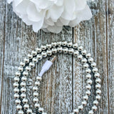 Gold pearl beaded 2 in 1 phone charging cable coiled beside a phone with iPhone and USB-C tips