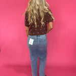Full length view of the cocoa brown polka dot cardigan worn open with denim and booties