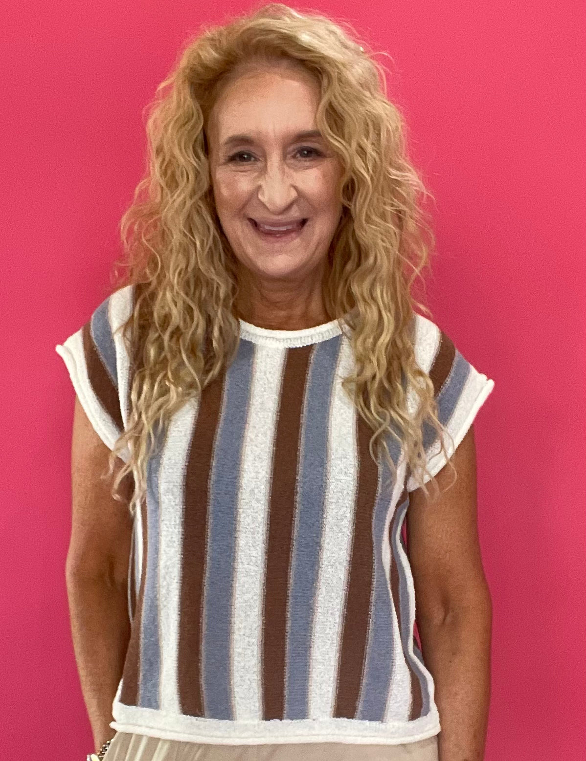 Woman wearing a blue and brown striped short sleeve knit sweater top with high waist jeans