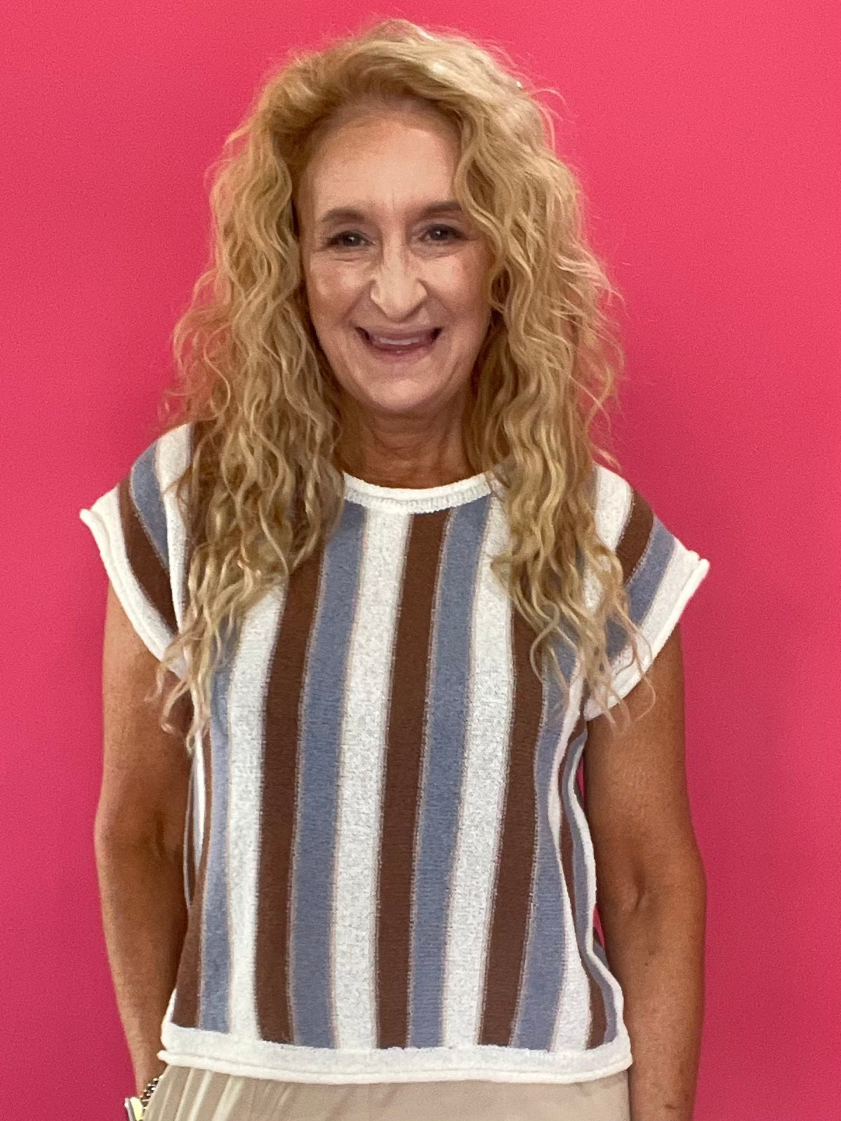 Woman wearing a blue and brown striped short sleeve knit sweater top with high waist jeans
