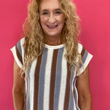 Woman wearing a blue and brown striped short sleeve knit sweater top with high waist jeans