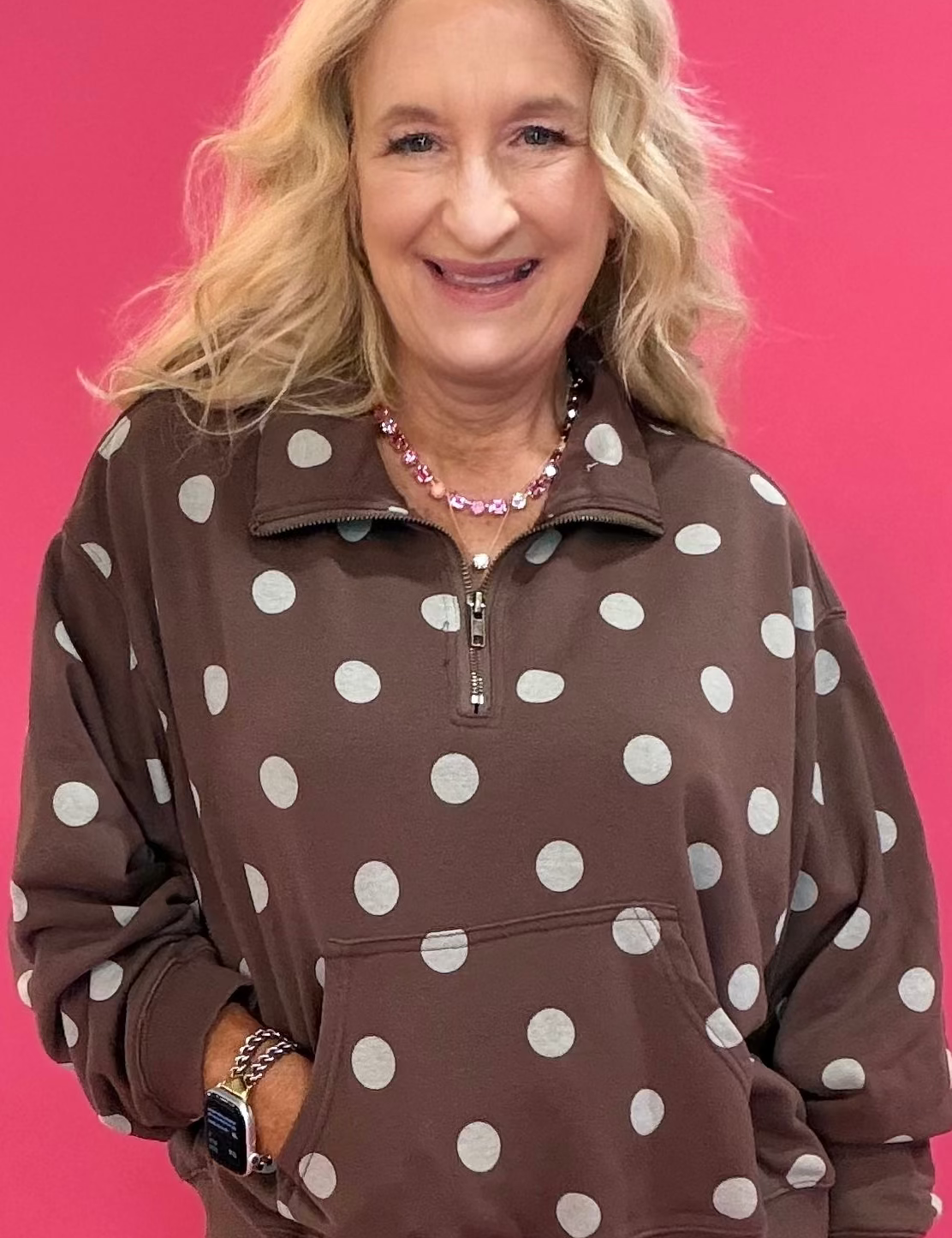 Woman wearing a brown mineral wash quarter zip pullover with polka dot texture over leggings and sneakers