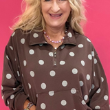 Woman wearing a brown mineral wash quarter zip pullover with polka dot texture over leggings and sneakers