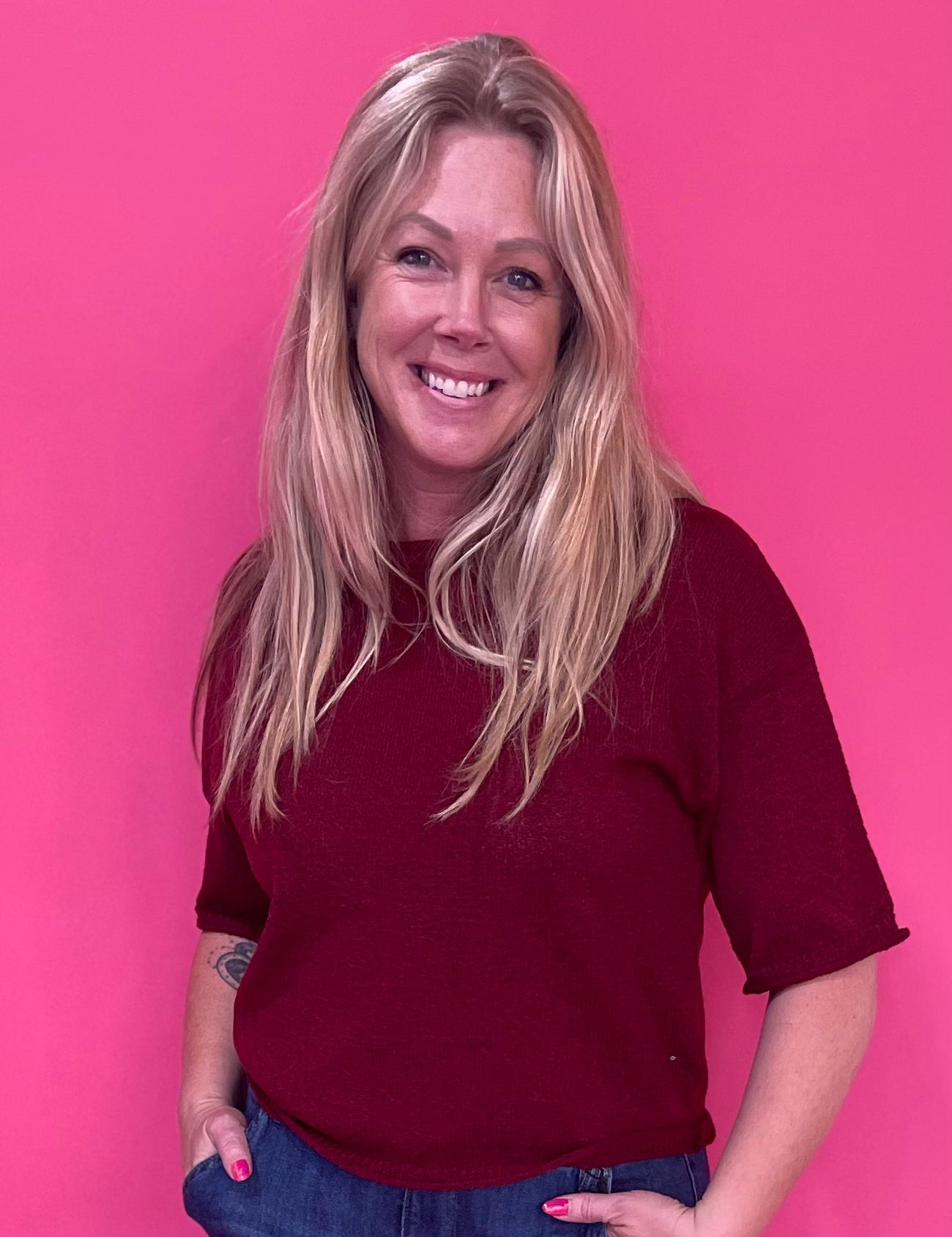 Woman wearing a burgundy soft knit pullover sweater with a relaxed fit and ribbed crew neck