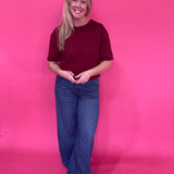 Side view of the burgundy pullover sweater worn with tailored trousers for the office