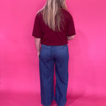 Flat lay of the burgundy knit pullover sweater folded to show the sleeve and ribbed cuff