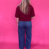 Flat lay of the burgundy knit pullover sweater folded to show the sleeve and ribbed cuff