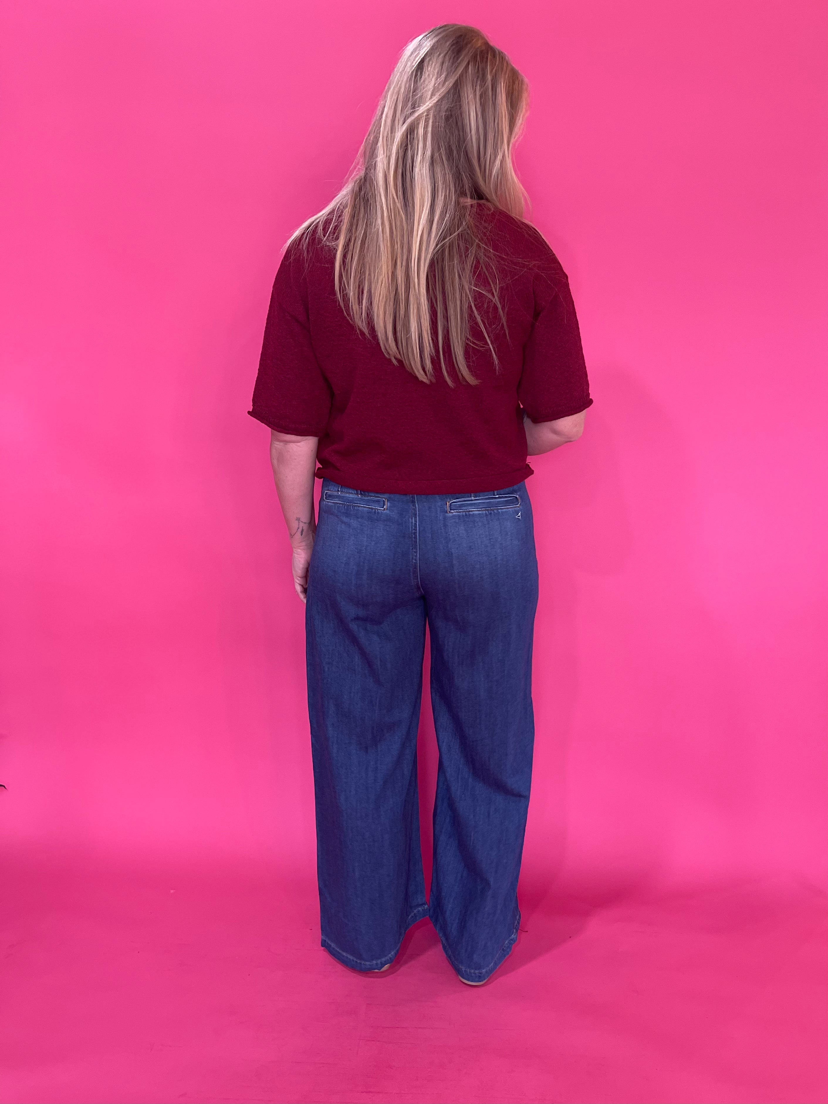 Flat lay of the burgundy knit pullover sweater folded to show the sleeve and ribbed cuff