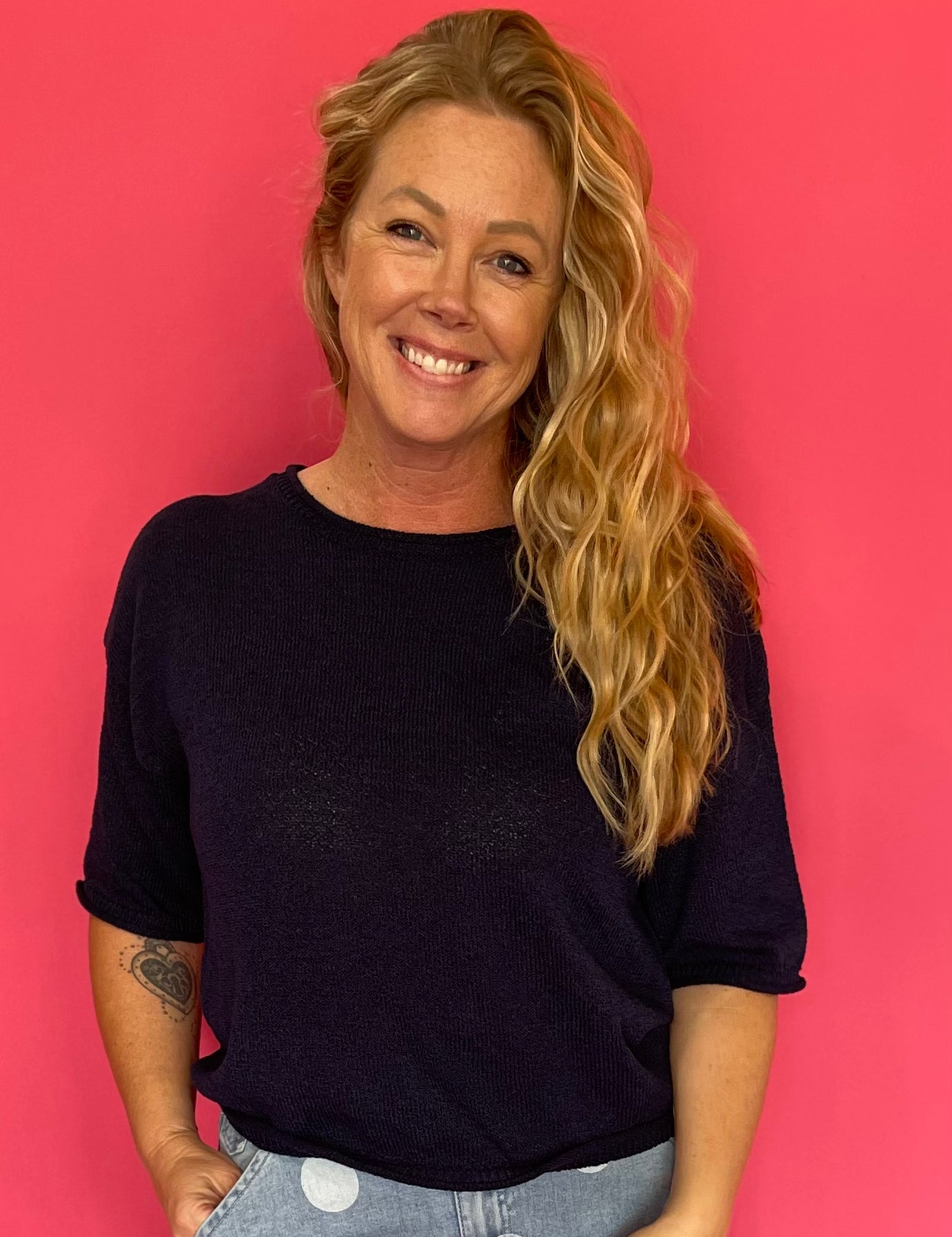 Woman wearing a navy soft knit pullover sweater with a relaxed fit and a ribbed crew neckline