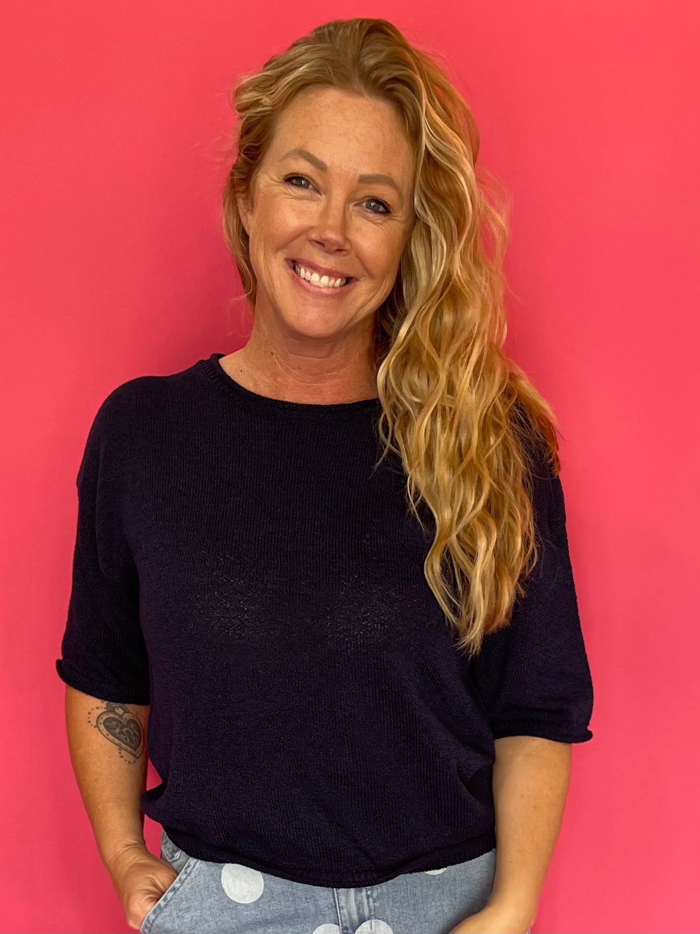 Woman wearing a navy soft knit pullover sweater with a relaxed fit and a ribbed crew neckline