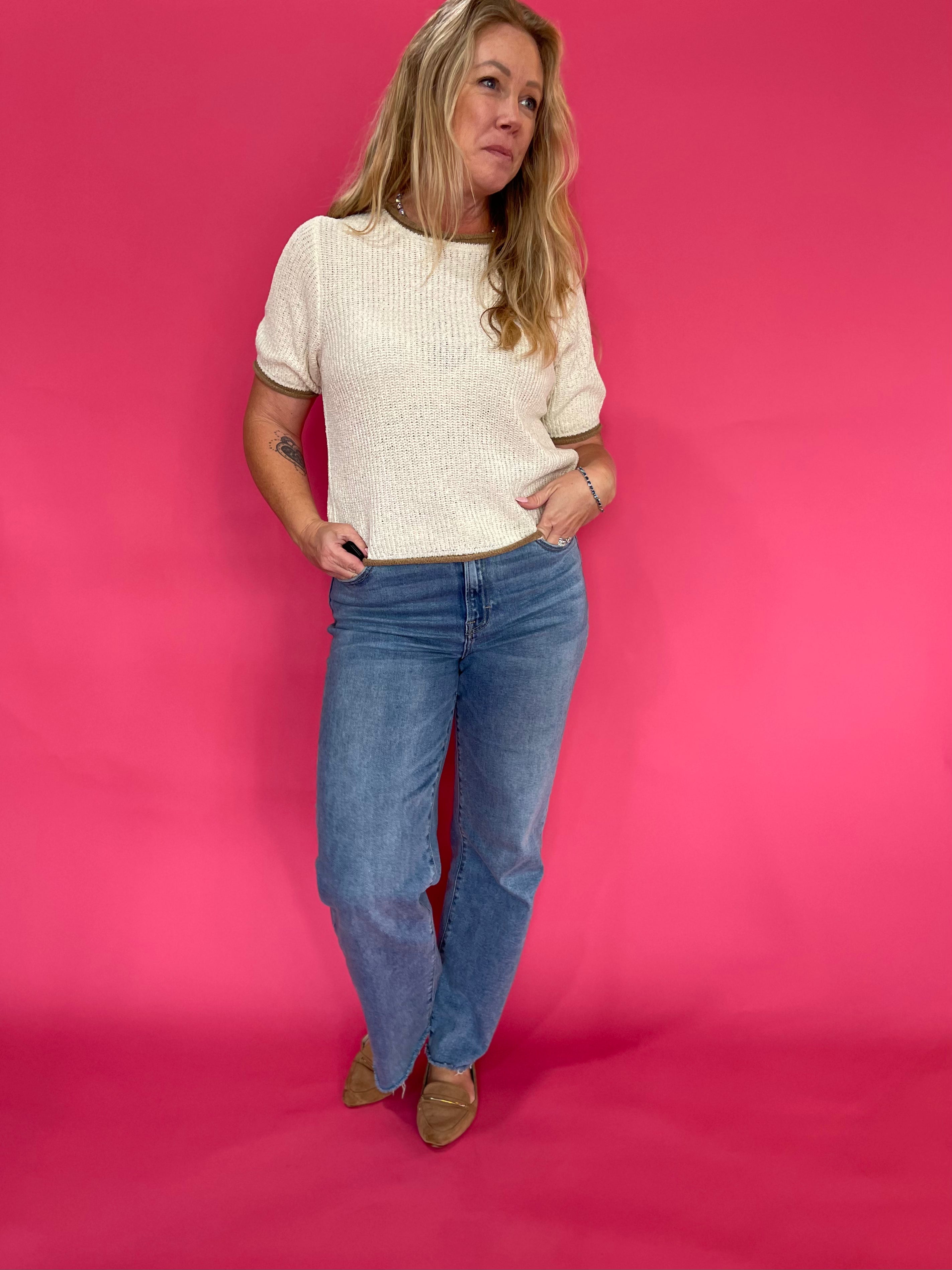 Flat lay of the oatmeal knit pullover sweater folded to show the sleeve and ribbed cuff detail