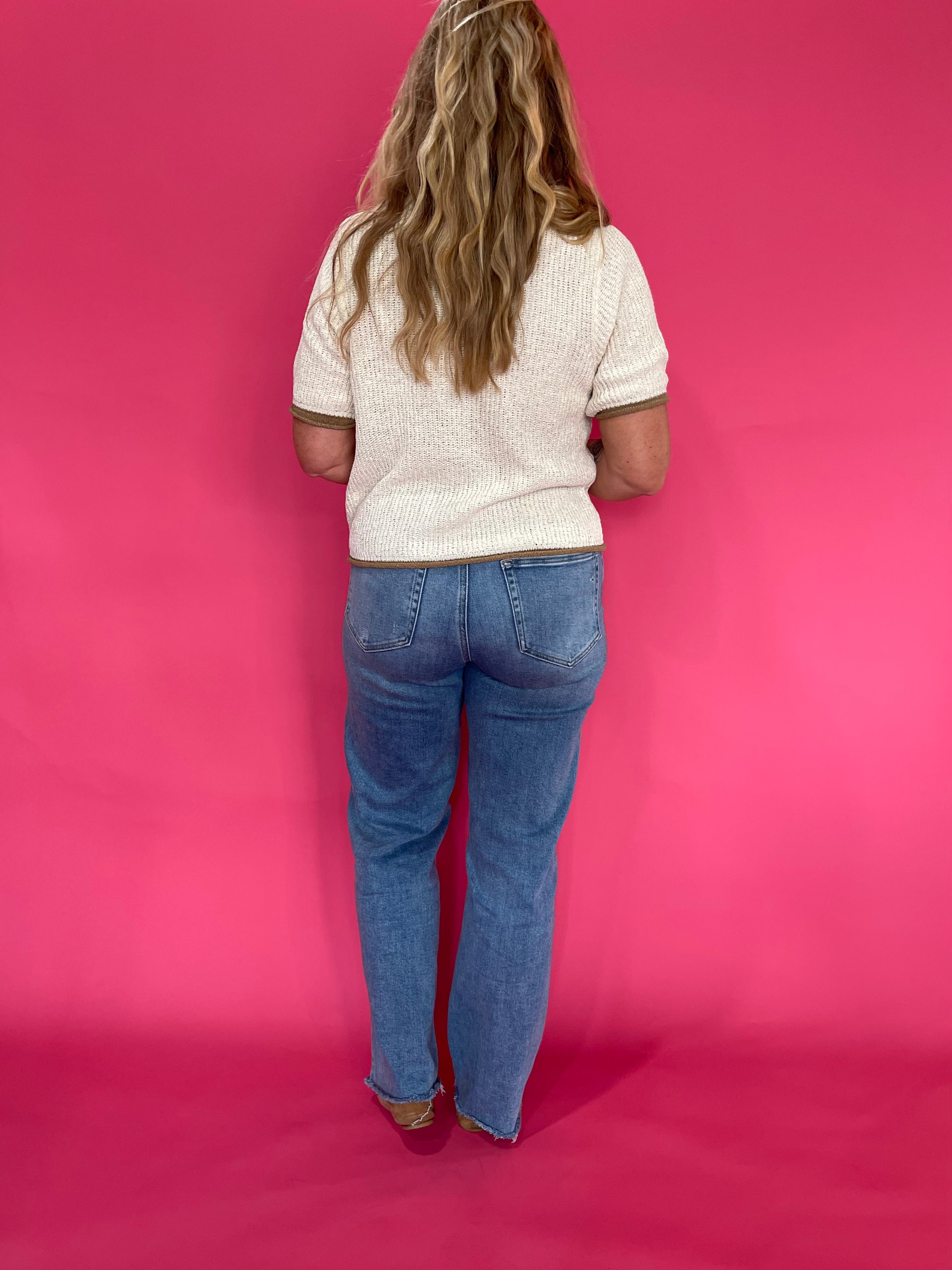 Full length view of the oatmeal knit pullover sweater worn with blue denim jeans