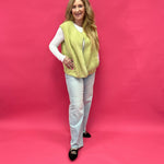 Close-up of the plush chartreuse sherpa texture and functional front button on the vest