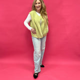 Close-up of the plush chartreuse sherpa texture and functional front button on the vest