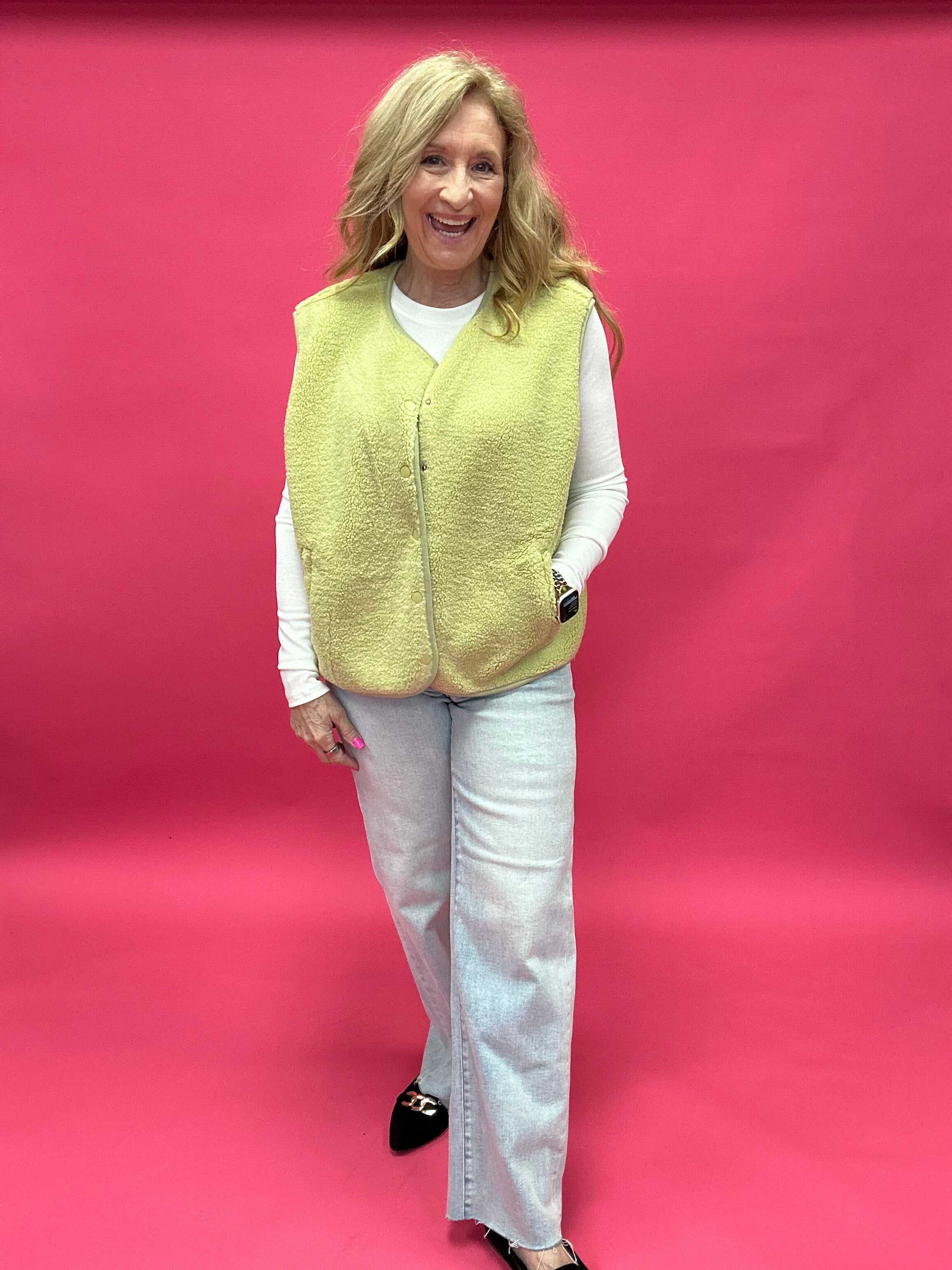 Back view of the chartreuse sherpa vest showing the relaxed layering fit through the body