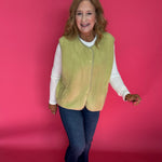 Woman styling the chartreuse sherpa vest over a turtleneck with leggings and boots