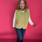 Woman styling the chartreuse sherpa vest over a turtleneck with leggings and boots