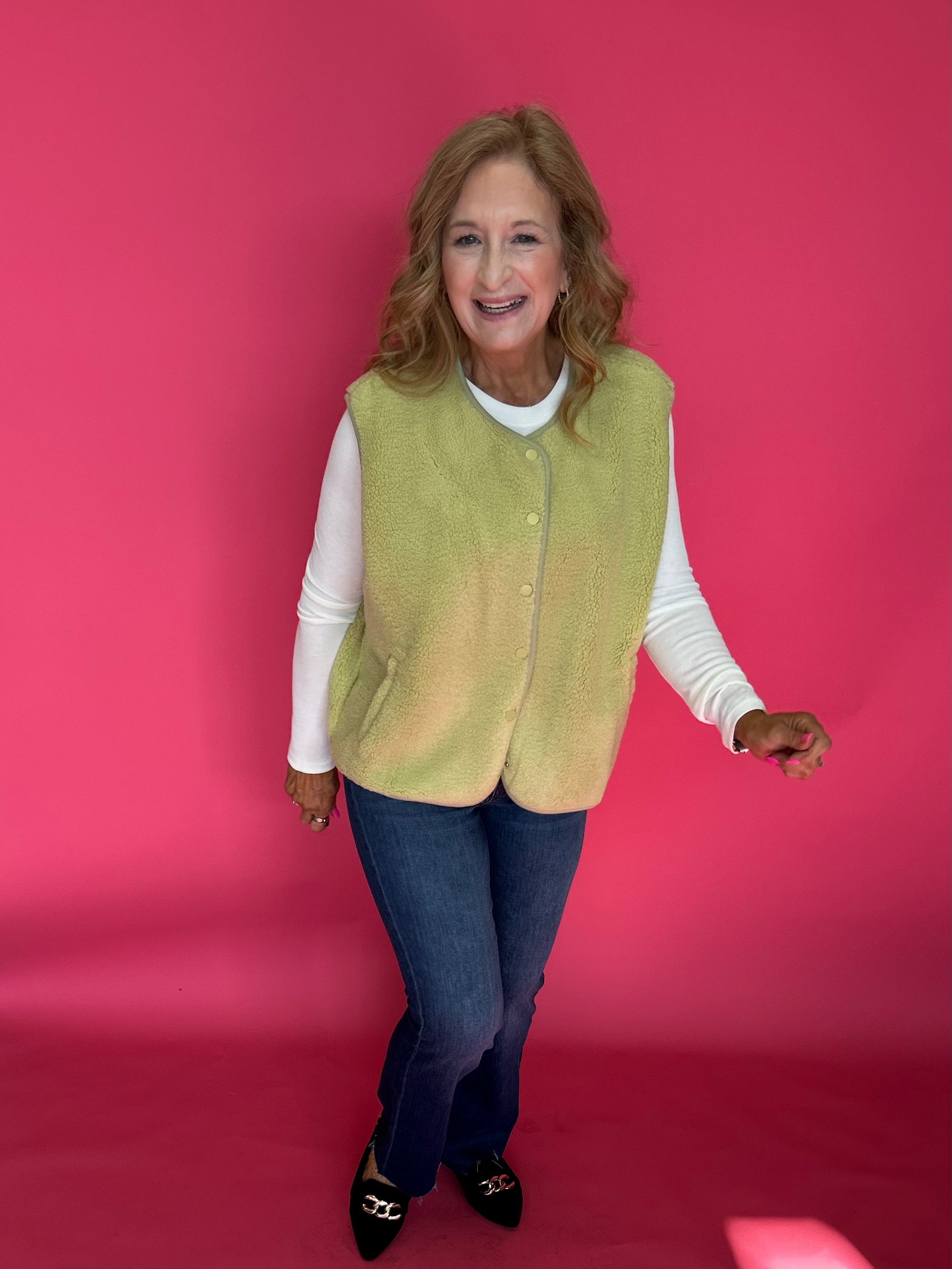 Woman styling the chartreuse sherpa vest over a turtleneck with leggings and boots