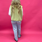 Flat lay of the chartreuse sherpa vest showing the button front, side pockets, and collar