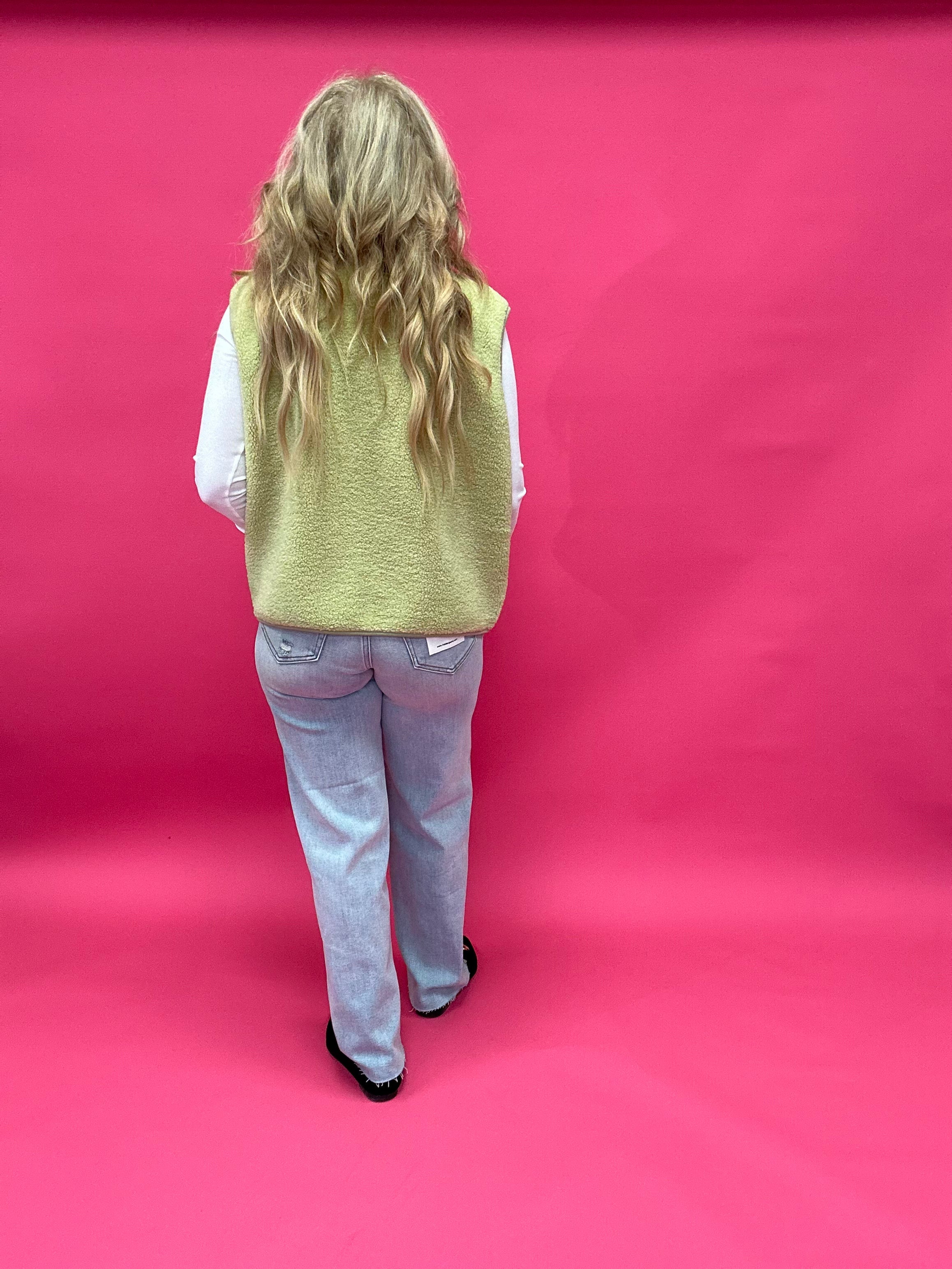 Flat lay of the chartreuse sherpa vest showing the button front, side pockets, and collar
