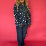 Close-up of the cream polka dot print and button front placket on the dark wash denim jacket