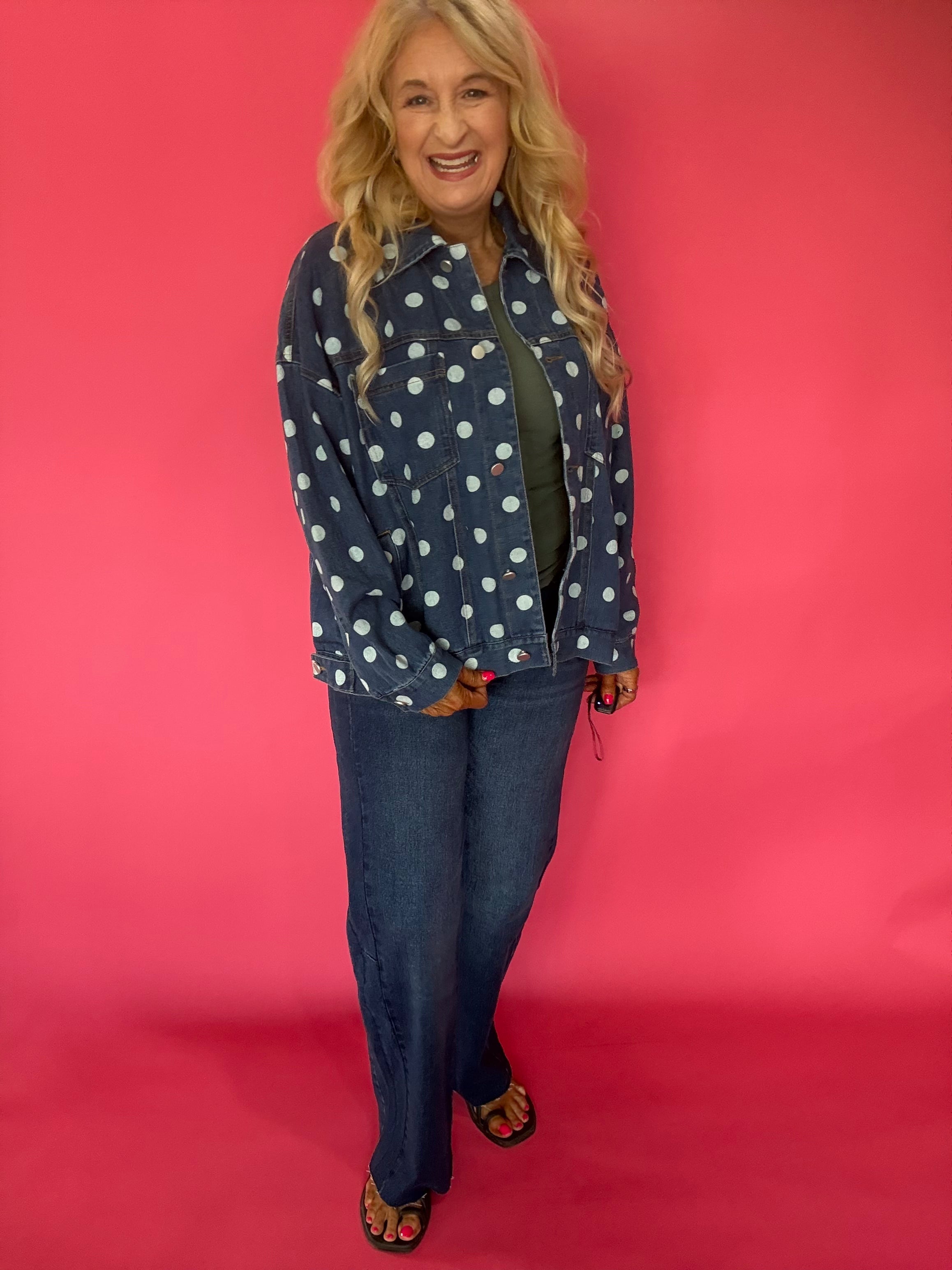 Close-up of the cream polka dot print and button front placket on the dark wash denim jacket