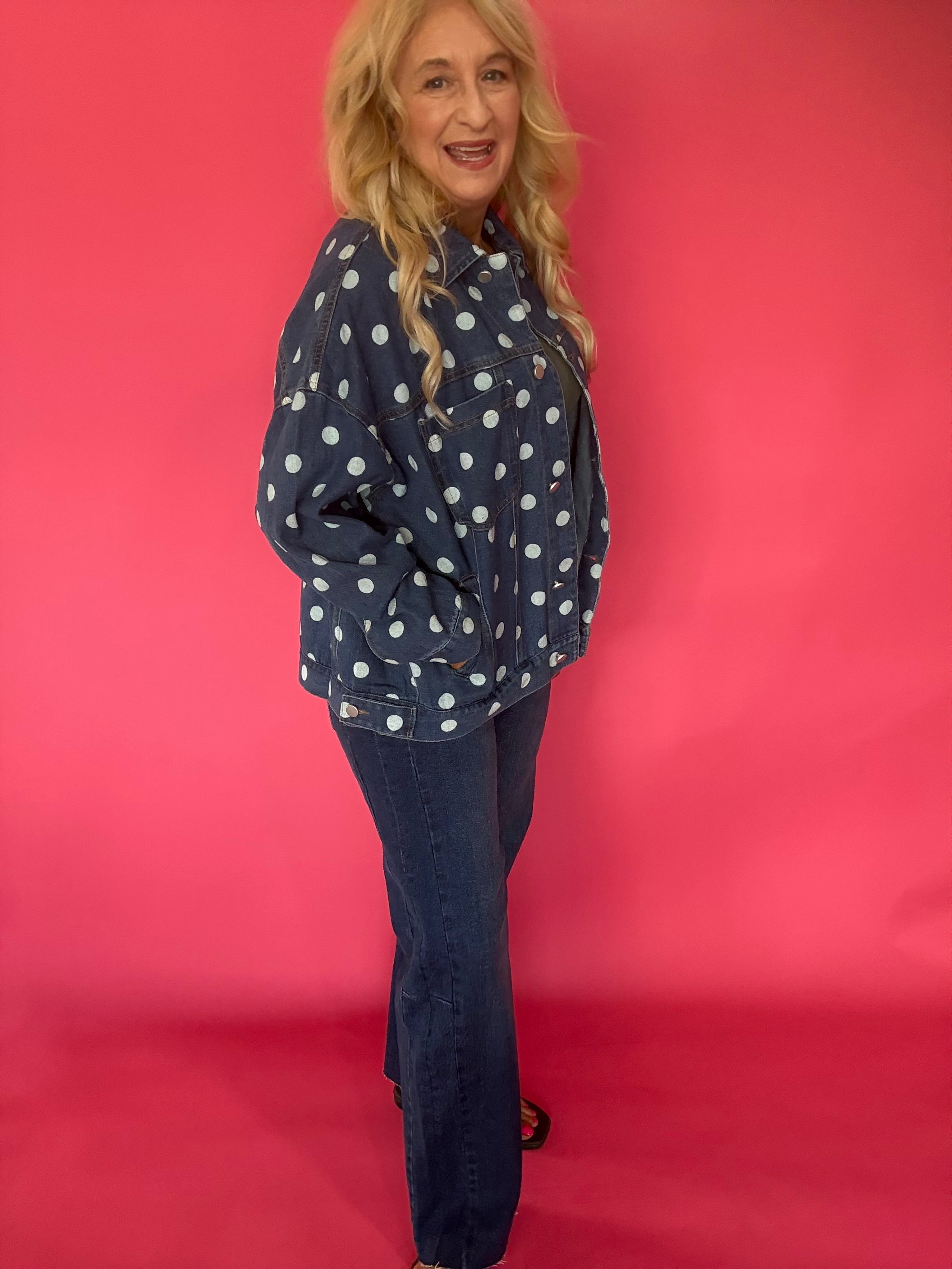 Detail of the chest pocket and contrast topstitching on the dark denim polka dot jacket