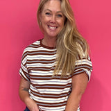 Woman wearing an oversized rust and cream striped tee with drop shoulders over denim cutoffs