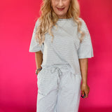 Woman wearing a striped ribbed knit lounge set with an oversized top and wide leg pants