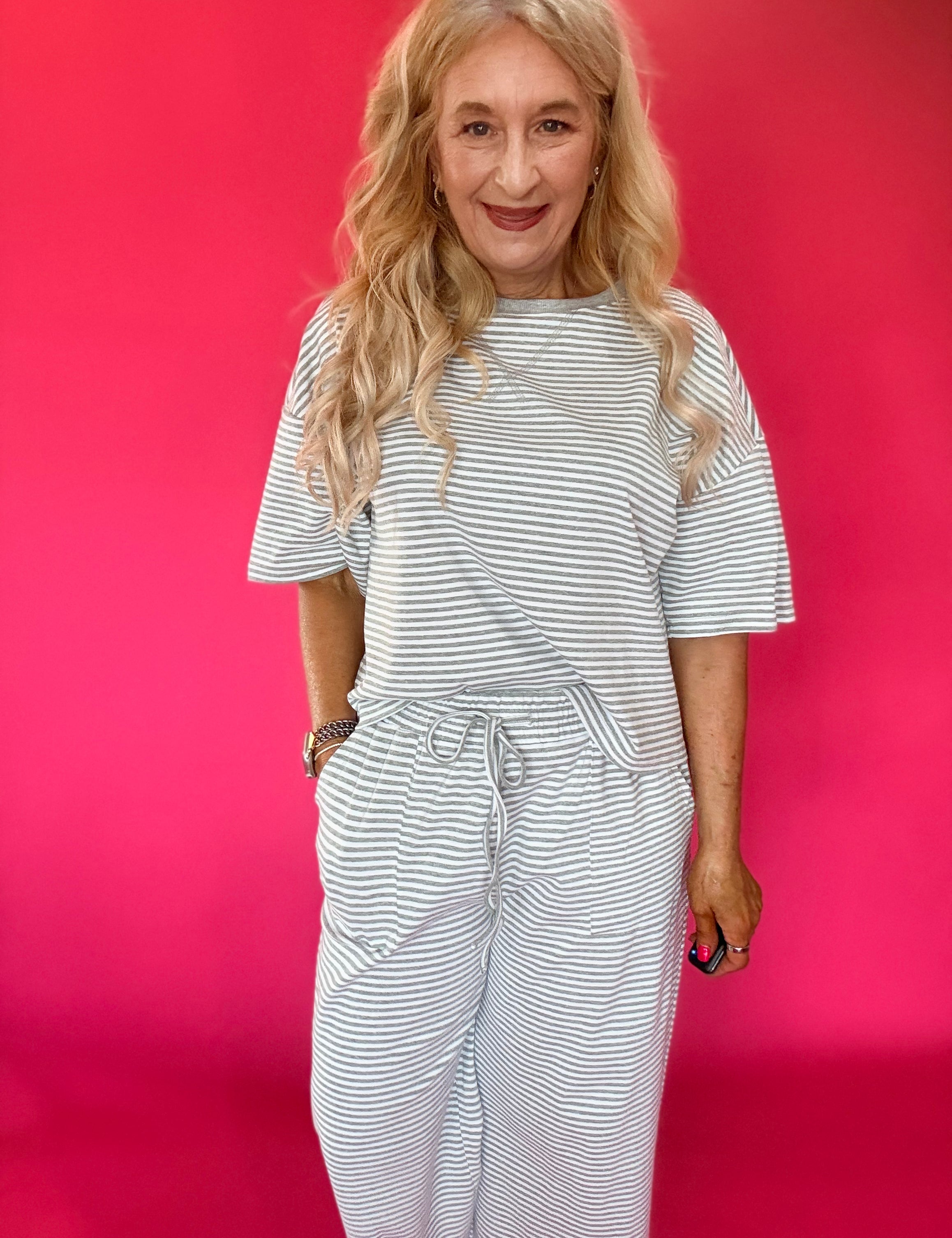 Woman wearing a striped ribbed knit lounge set with an oversized top and wide leg pants