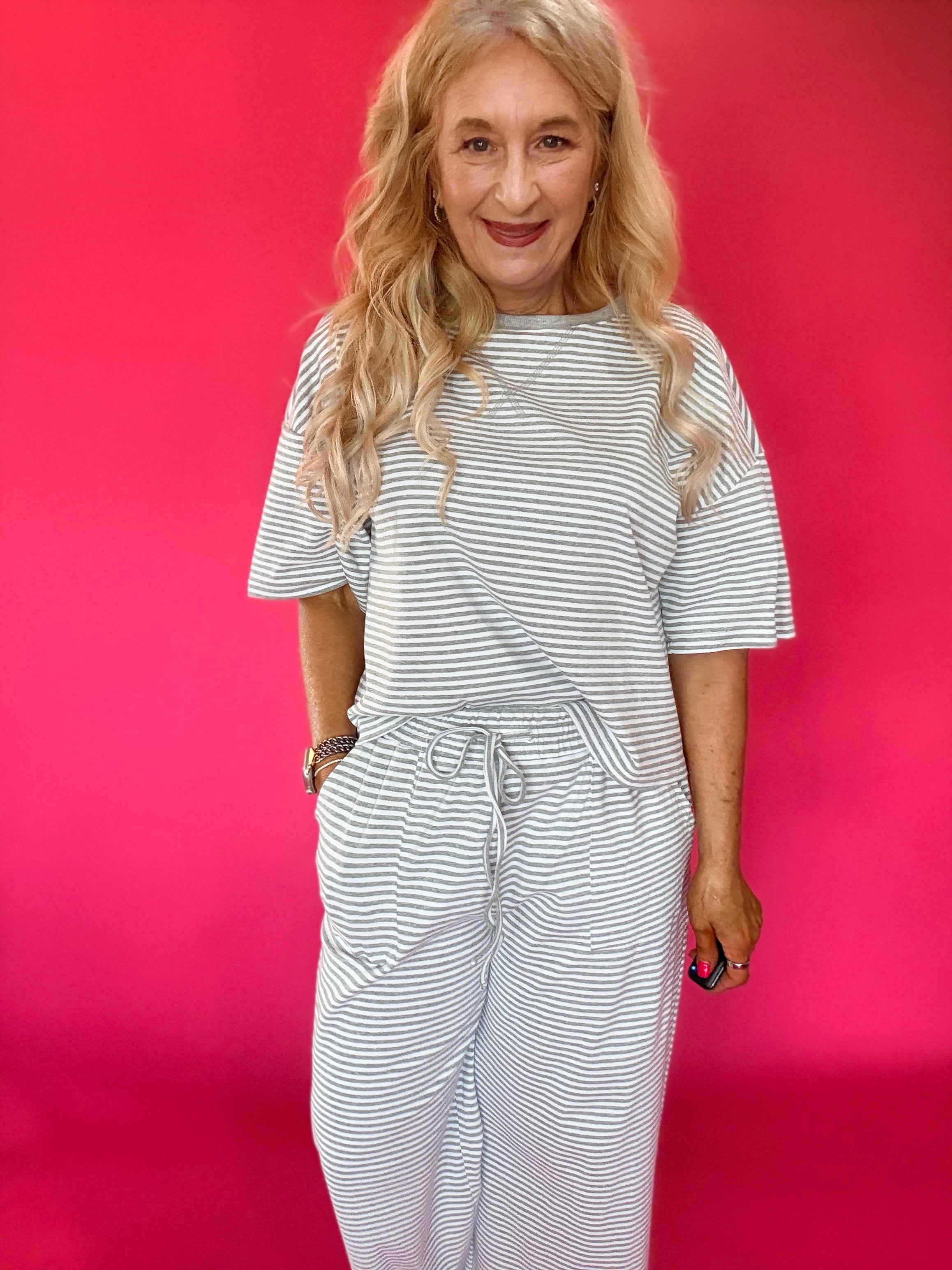 Woman wearing a striped ribbed knit lounge set with an oversized top and wide leg pants