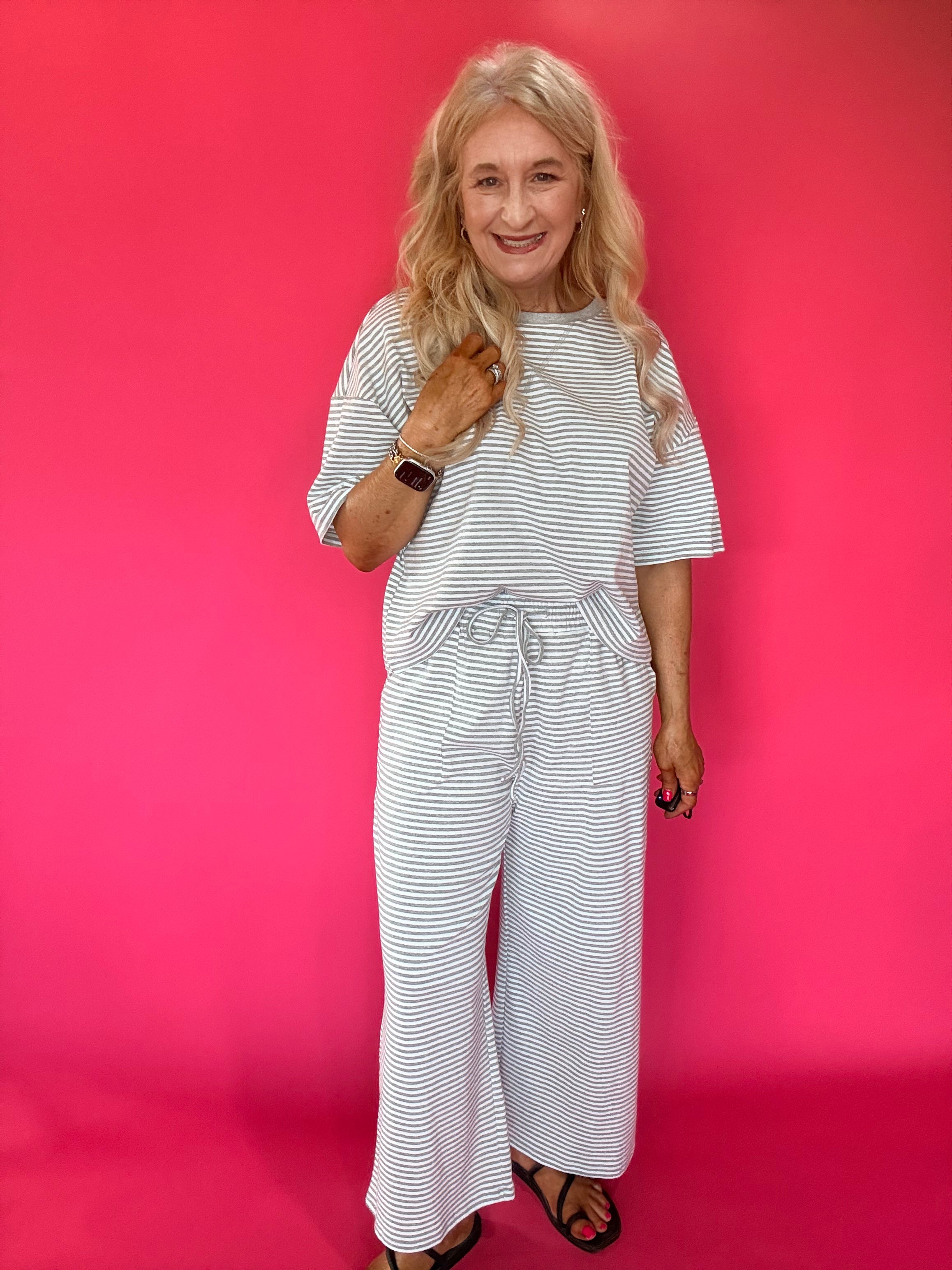 Side view of the lounge set showing the side pocket and wide leg hem with white sneakers