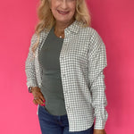 Side view of the green ribbed tank layered under an open cardigan with denim for fall